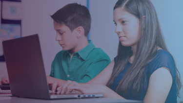 Two latino children at laptops